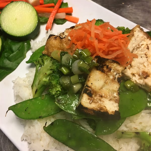 Grilled tofu with snow peas, broccoli, shredded carrots, and scallions over white rice.